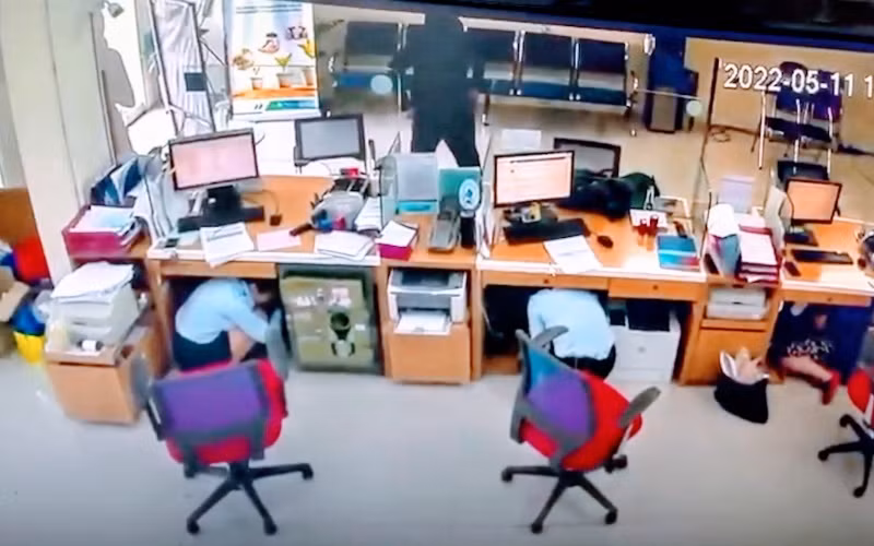 Hình ảnh tên cướp uy hiếp nhân viên ngân hàng định cướp tiền. (Ảnh cắt từ camera)