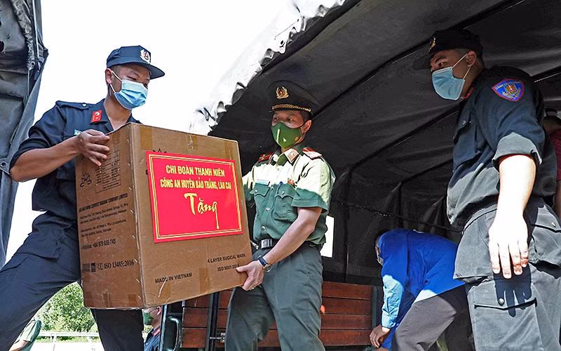 Các chiến sĩ trẻ tình nguyện của lực lượng Công an TP Hà Nội và tỉnh Lào Cai vận chuyển trang thiết bị y tế, nhu yếu phẩm hỗ trợ Thủ đô chống dịch.