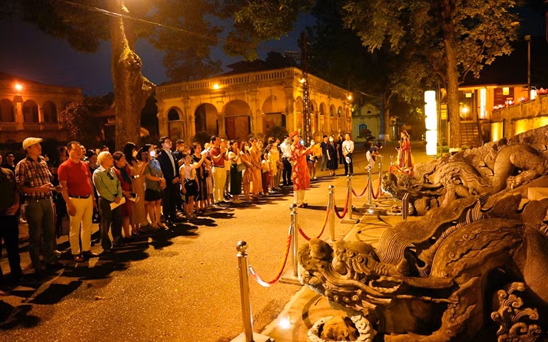 Khách du lịch dâng hương trước thềm điện Kính Thiên trong tua đêm Giải mã Hoàng thành Thăng Long.