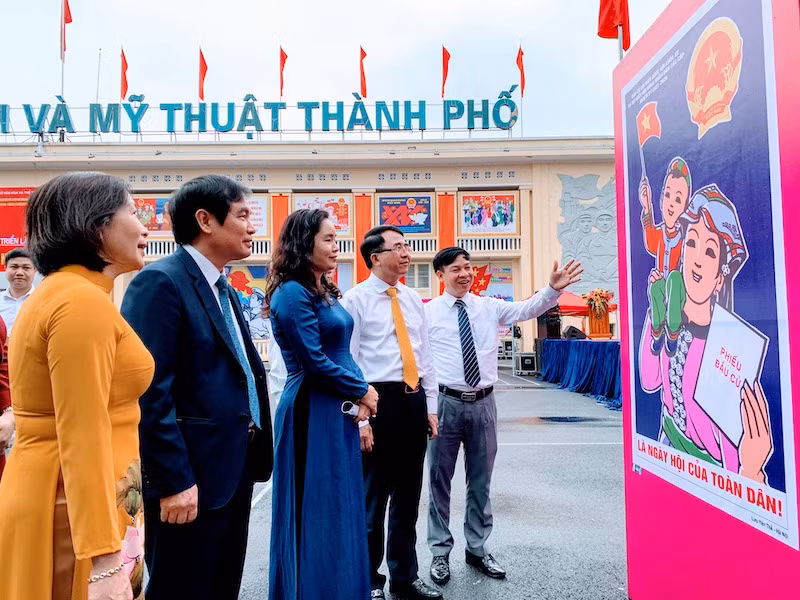 Các đại biểu xem tranh cổ động trưng bày tại triển lãm