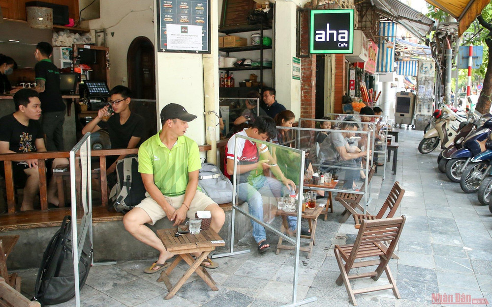 Ghi nhận của PV, nhiều hàng quán đã chấp hành việc giãn cách. Trong ảnh, một cửa hàng đồ uống trên phố Hàng Mã đã tiến hành làm các vách ngăn bằng mica để bảo đảm một một bàn sẽ có một không gian riêng. Hàng quán Hà Nội dựng vách ngăn phòng Covid-19 -0