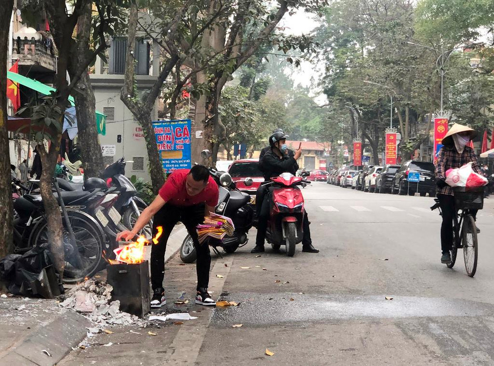 Một gia đình trên phố Tô Hiến Thành hóa vàng sau lễ cúng, trước khi mang cá đi thả. Người dân Hà Nội thả cá chép tiễn ông Táo về trời -0