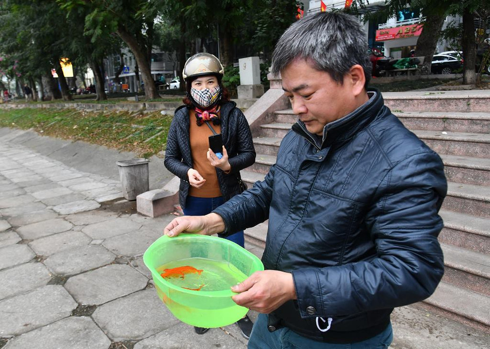 Người dân đã có ý thức bảo vệ môi trường, mang theo bình nhựa, chậu nhựa đi thả cá để giảm rác thải túi nilon. Người dân Hà Nội thả cá chép tiễn ông Táo về trời -0