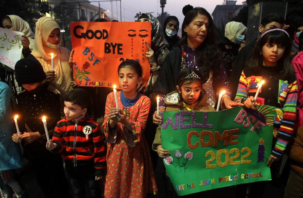 Các em nhỏ cùng tham gia cầu nguyện cho hòa bình trong năm mới 2022 ở Lahore, Pakistan. (Ảnh: EPA) Thế giới chào năm mới 2022 trong bối cảnh thắt chặt quy định phòng, chống dịch Covid-19 -0