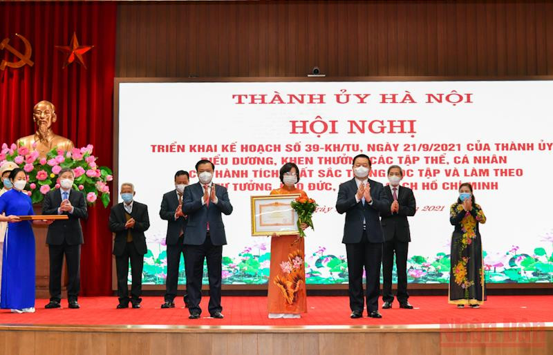 Bí thư Thành ủy Đinh Tiến Dũng và Trưởng Ban Tuyên giáo Trung ương Nguyễn Trọng Nghĩa trao bằng khen cho Ban Tuyên giáo Thành ủy Hà Nội. (Ảnh: Duy Linh) 