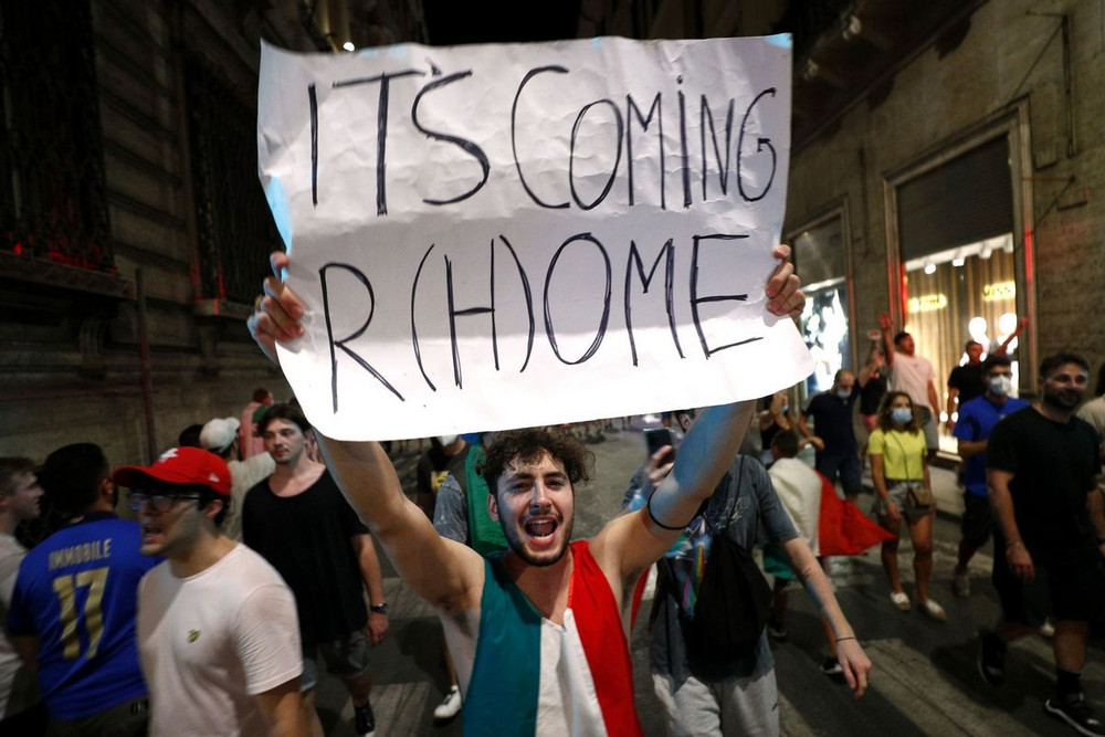 Một fan hâm mộ Italia ăn mừng với tấm băng rôn ghi dòng chữ “bóng đá đang trở về Roma”, dựa trên câu cổ động nổi tiếng của người hâm mộ tuyển Anh “bóng đá đang trở về nhà”. (Ảnh: Reuters) Niềm vui và nước mắt - hai chiều cảm xúc trái ngược sau chung kết EURO 2020 -0
