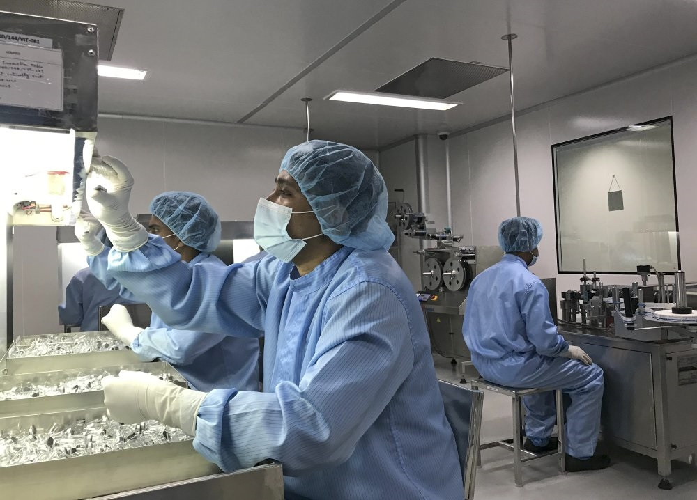 Nhân viên sản xuất thực hiện kiểm tra các lọ vaccine bên trong nhà máy Incepta ở Bangladesh. Ảnh: AP. Chia sẻ bí quyết vaccine Covid-19 trong đại dịch: Mong đợi của nước nghèo -0
