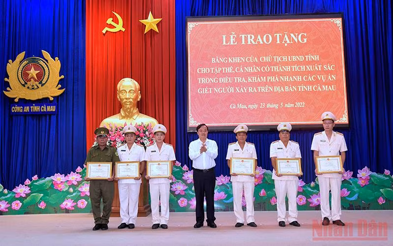 Chủ tịch Ủy ban nhân dân tỉnh Cà Mau (áo trắng) tặng Bằng khen cho các cá nhân phá nhanh các vụ trọng án. 