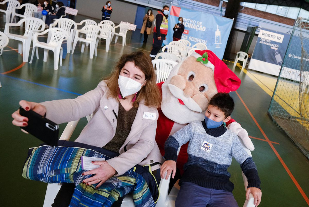 Các bác sĩ và y tá trong trang phục Giáng sinh, hóa trang thành ông già Noel chụp ảnh cùng trẻ nhỏ và người thân tại trung tâm tiêm chủng Ajuda, khi Bồ Đào Nha bắt đầu chiến dịch tiêm ngừa Covid-19 cho trẻ từ 5 đến 11 tuổi, Lisbon, Bồ Đào Nha, ngày 18/12/2021. (Ảnh: Reuters) Châu Âu đón Giáng sinh trong lo ngại làn sóng Omicron -0