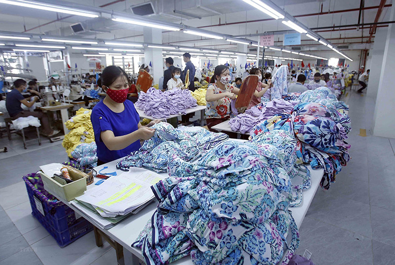 Sản xuất sản phẩm may mặc tại công ty TNHH may Hưng Long (thị xã Mỹ Hào, Hưng Yên). (Ảnh: Phạm Kiên/TTXVN) Ngân sách nhà nước năm 2021 vượt đích ngoạn mục trong bão dịch -0