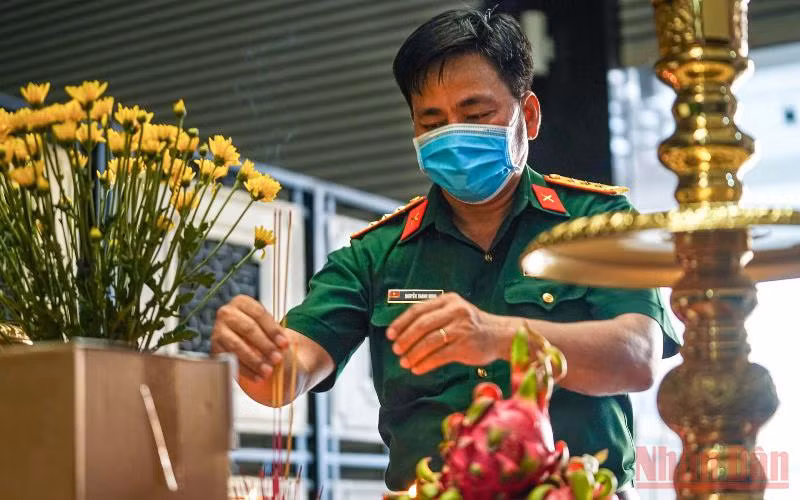 Cán bộ thuộc Bộ Tư lệnh thành phố Hồ Chí Minh thắp hương cho các nạn nhân tử vong vì Covid-19. (Ảnh: HOÀNG TRIỀU)