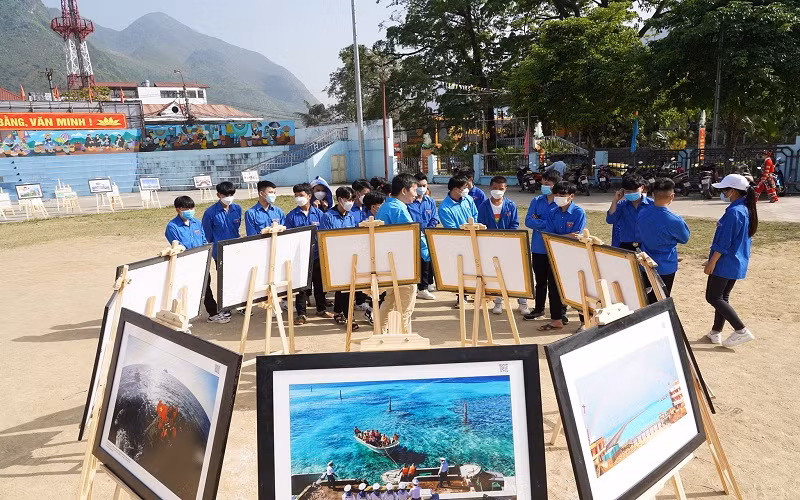 Đoàn viên, thanh niên Hà Giang tham quan và nghe thuyết minh về biển, đảo qua những bức ảnh.