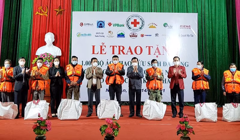 Nguyên Chủ tịch nước Trương Tấn Sang cùng lãnh đạo Trung ương Hội Chữ thập đỏ Việt Nam, tỉnh Nghệ An và nhà tài trợ trao tặng áo phao cho ngư dân Cửa Lò. 