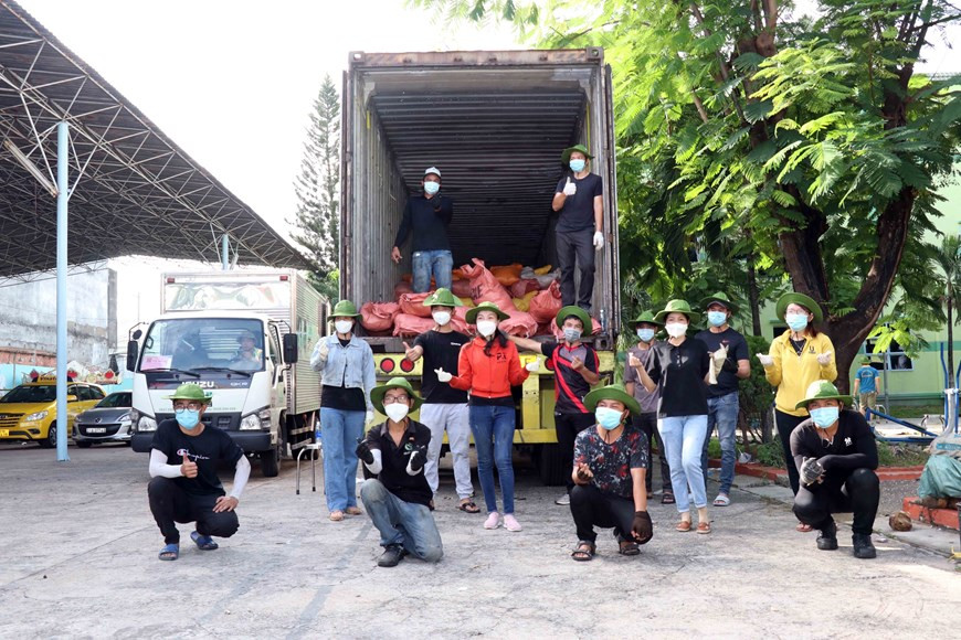 Tình nguyện viên trẻ làm công tác hỗ trợ vận chuyển, phân phối hàng cứu trợ của các địa phương về đến người dân thành phố. (Ảnh: Xuân Khu/TTXVN) Những chuyến xe đong đầy yêu thương đến với thành phố mang tên Bác -0