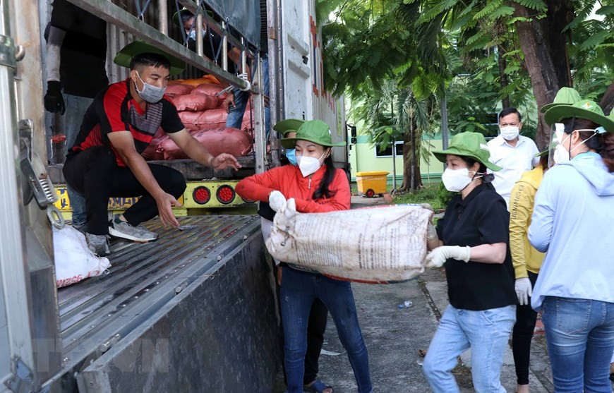 Lực lượng tình nguyện viên, cán bộ Mặt trận bốc xếp hàng hóa do chính quyền, nhân dân Quảng Trị tặng lên các xe vận tải nhỏ chuyển đến các khu tập trung, khu cách ly tại các quận, huyện của TP Hồ Chí Minh. (Ảnh: Xuân Khu/TTXVN) ttxvn_chuyen_xe_9-1626670101545.jpeg