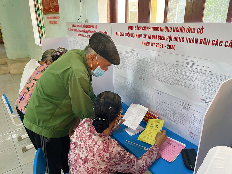 Cử tri là ngư dân Bảo Ninh, TP Đồng Hới tìm hiểu, viết tên ứng viên vào phiếu bầu. Cử tri cả nước nô nức đi bầu cử, thực hiện quyền công dân thiêng liêng -0