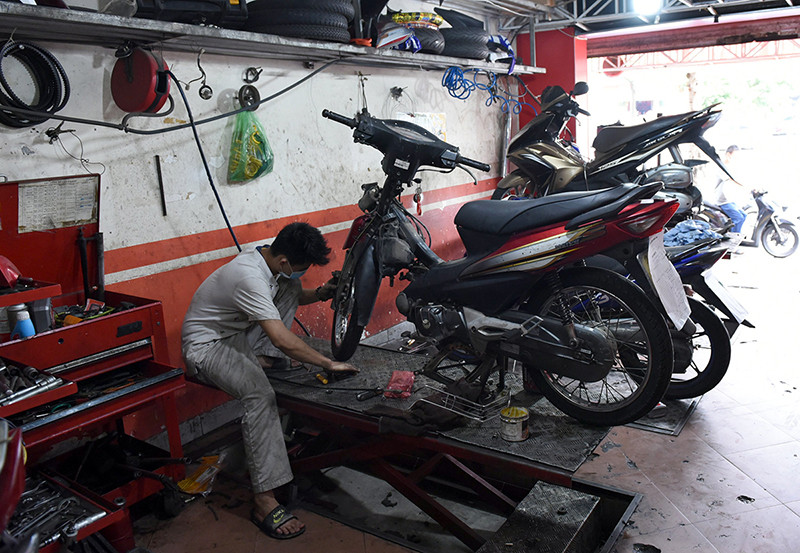 Cửa hàng sửa chữa xe máy trên phố Đội Cấn phục vụ khách trong ngày đầu mở cửa trở lại. “Vùng xanh” Hà Nội trong ngày đầu cơ sở kinh doanh mở cửa trở lại -0
