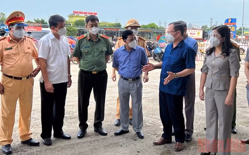 Lãnh đạo Trung tâm Y tế thị xã Nghi Sơn báo cáo thực thi các biện pháp phòng, chống dịch tại khu vực chốt kiểm soát Khe nước lạnh. (Ảnh: MAI LUẬN) 