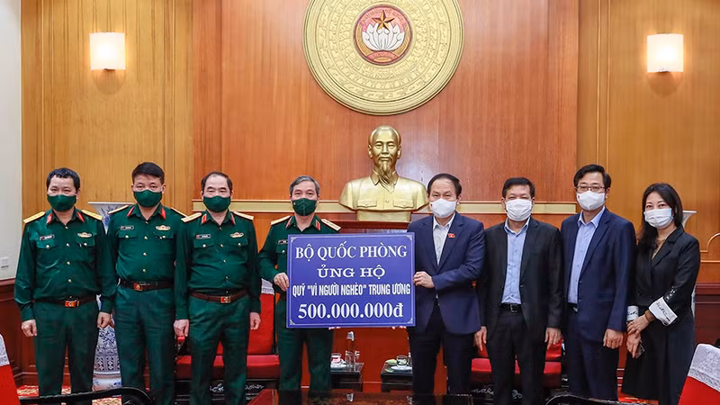 Trao biểu trưng số tiền 500 triệu đồng Bộ Quốc phòng ủng hộ Quỹ "Vì người nghèo" Trung ương. (Ảnh: Quang Vinh)