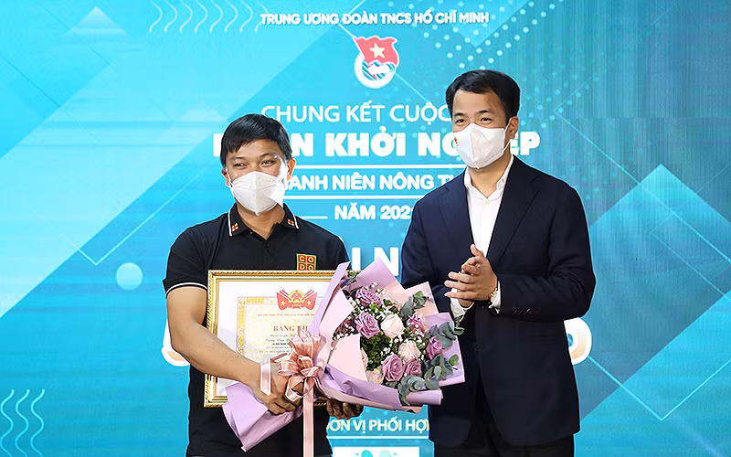 Tác giả dự án “Nông trại Cờ Đỏ”, anh Lương Văn Trường (bên trái trong ảnh) nhận giải nhất Cuộc thi “Dự án khỏi nghiệp thanh niên nông thôn” năm 2021.