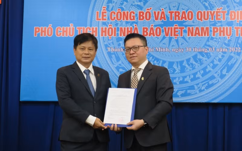 Đồng chí Lê Quốc Minh, Ủy viên Trung ương Đảng, Tổng Biên tập Báo Nhân Dân, Phó Trưởng Ban Tuyên giáo Trung ương, Chủ tịch Hội Nhà báo Việt Nam, trao quyết định cho ông Trần Trọng Dũng.