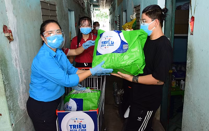Tình nguyện viên trao nhu yếu phẩm của chương trình “Triệu bữa cơm” tặng ngươi dân có hoàn cảnh khó khăn tại TP Hồ Chí Minh.