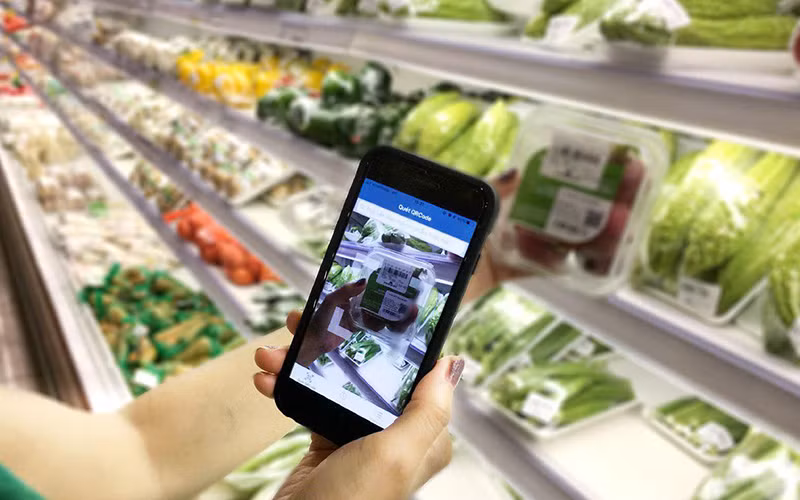 Người tiêu dùng truy xuất nguồn gốc thực phẩm bày bán tại siêu thị.