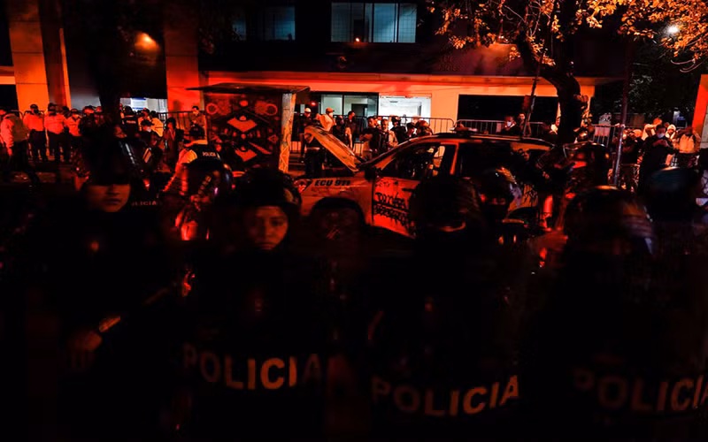 Cảnh sát chống bạo động Ecuador bảo vệ phương tiện của Cảnh sát sau khi xe này bị tấn công tại Quito, ngày 14/6. (Ảnh: Reuters)