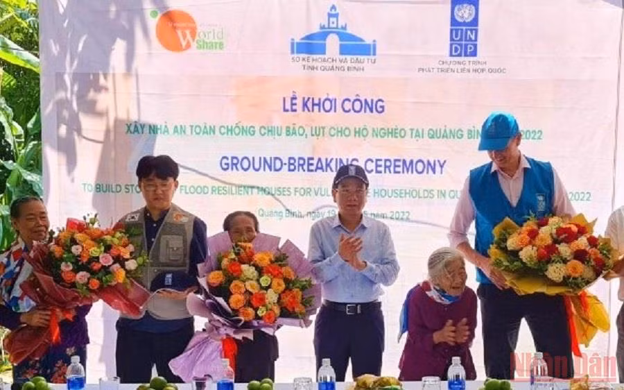 Tặng hoa các hộ dân được hỗ trợ xây nhà tại huyện Quảng Ninh.