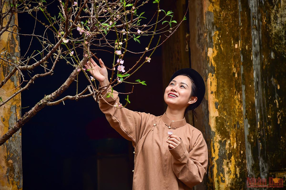 Thiếu nữ bên cành đào báo hiệu mùa Xuân đang đến. (Ảnh: Thành Đạt) Tái hiện hình ảnh Tết xưa – lưu giữ những giá trị truyền thống tốt đẹp -0