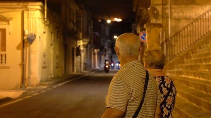 Người dân nhìn đám cháy thiêu rụi một khu rừng thông từ làng Giarratana, trên đảo Sicily, Italia vào ngày 11/8. (Ảnh cắt từ video, nguồn: Reuters).