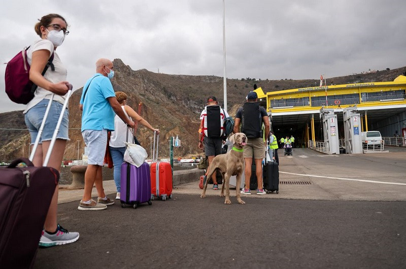 Du khách xếp hàng dài tại cảng chính La Palma để chờ lên phà rời đảo. (Ảnh: Reuters) Núi lửa đảo La Palma hoạt động tăng cường, sân bay buộc phải đóng cửa -0