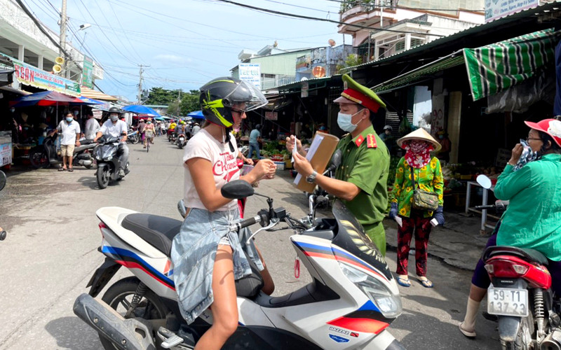 Cán bộ công an TP Phú Quốc nhắc nhở một trường hợp người nước ngoài không đeo khẩu trang khi di chuyển trên đường. Phú Quốc phát hiện 18 F0 trong ngày đầu thực hiện Chỉ thị 19 -0