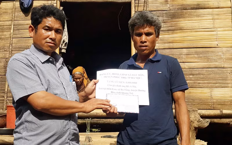 Lãnh đạo UBND xã Ba Tầng trao quà tặng anh Hồ A Tia. 