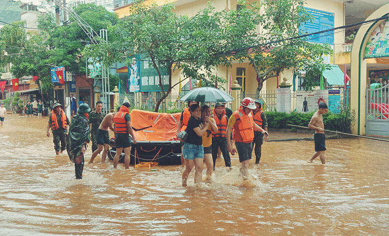 Lực lượng chức năng hỗ trợ người dân từ vùng ngập úng đến nơi an toàn. Mưa lũ tại Hà Giang khiến ba người chết -0