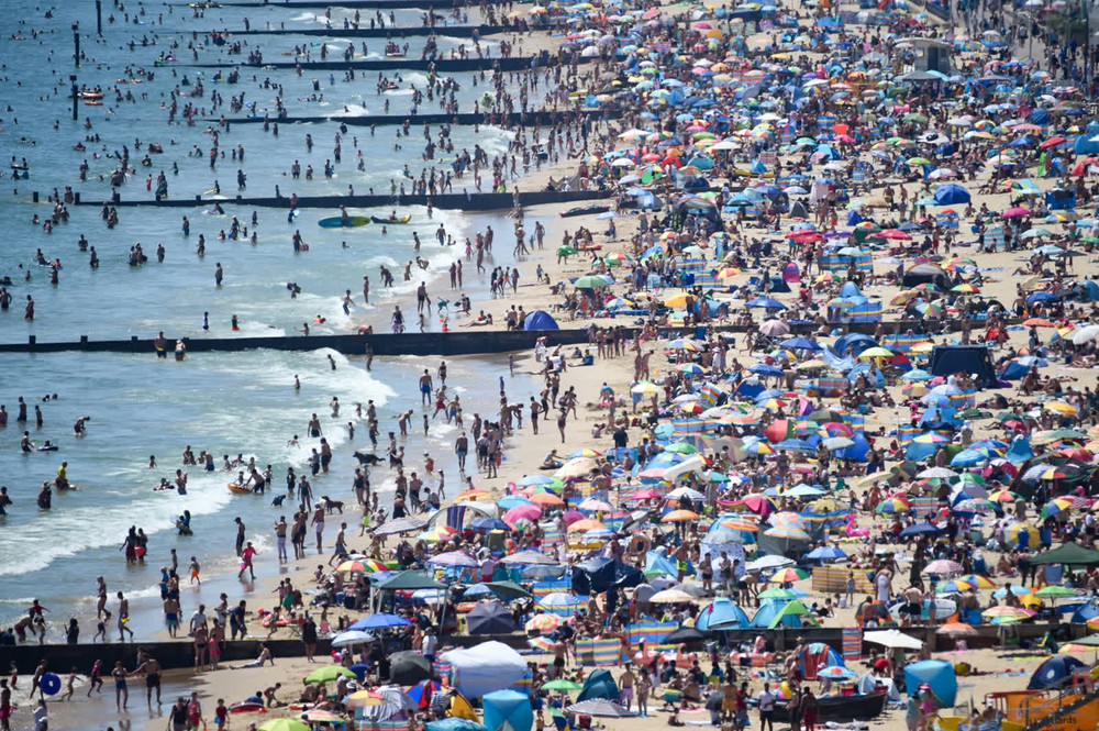 Người dân Anh đổ xô đến bãi biển Bournemouth để giải nhiệt trong mùa hè. Từ tháng 5, Thủ tướng Boris Johnson ra lệnh nới lỏng các biện pháp hạn chế nhằm ngăn ngừa sự lây lan của Covid-19. Tuy nhiên, sau đó dịch bệnh tại nước này đã diễn biến phức tạp. (Ảnh: Getty Images) 1 -0
