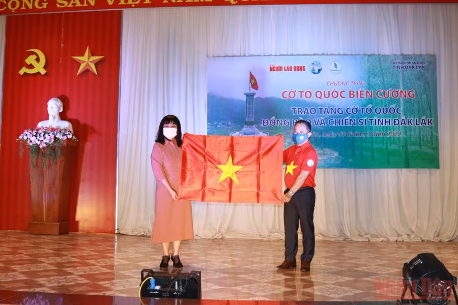 Phó Tổng Biên tập Báo Người lao động Bùi Thanh Liêm, trao tặng lá cờ Tổ quốc của Chủ tịch nước gửi tặng chương trình cho Phó Chủ tịch Ủy ban nhân dân tỉnh Đắk Lắk H’Yim Kdoh.