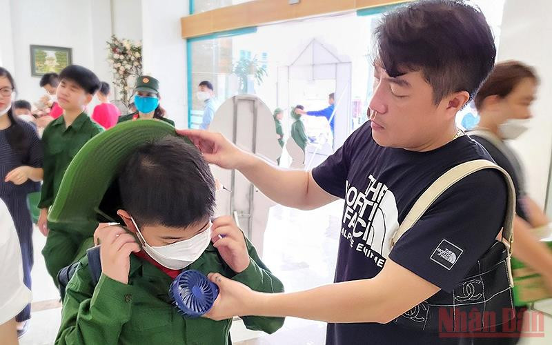 Một chiến sĩ “nhí” được bố chỉnh lại trang phục trước khi đứng vào hàng. Chiến sĩ “nhí” lên đường tham gia “Học kỳ trong quân đội” -0