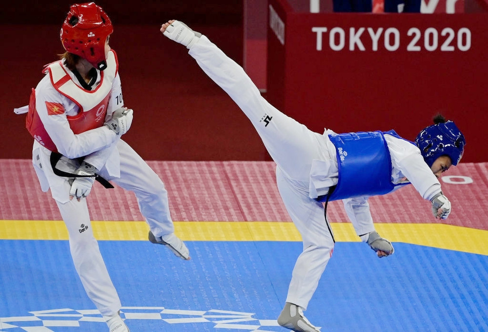 Kim Tuyền (áo đỏ) né tránh một đòn tấn công của đối phương. (Ảnh: Getty) Cầu lông, Taekwondo Việt Nam khởi đầu thuận lợi -0