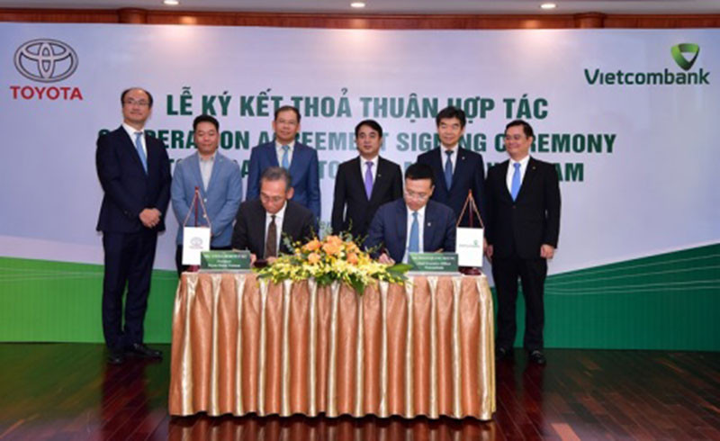 Ông Hiroyuki Ueda - Tổng Giám đốc Toyota VN (ngồi bên trái) và ông Phạm Quang Dũng - Tổng Giám đốc Vietcombank (ngồi bên phải) ký kết thỏa thuận hợp tác giữa Vietcombank và Toyota VN.
