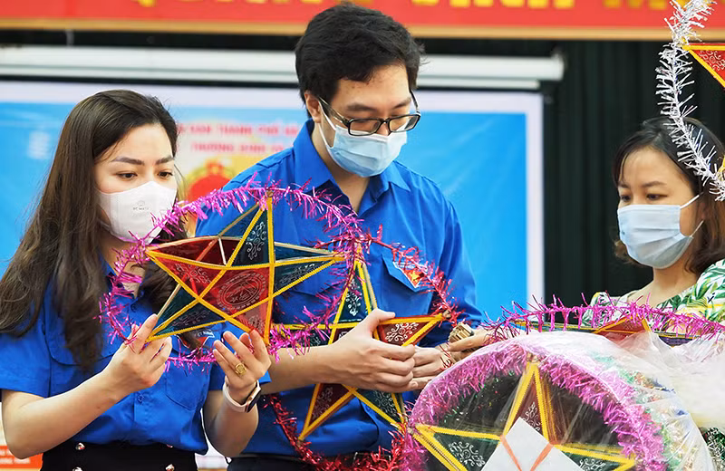 Các tình nguyện viên làm đèn ông sao tặng các em thiếu nhi tại Trung tâm Nuôi dưỡng người già và trẻ tàn tật Hà Nội.