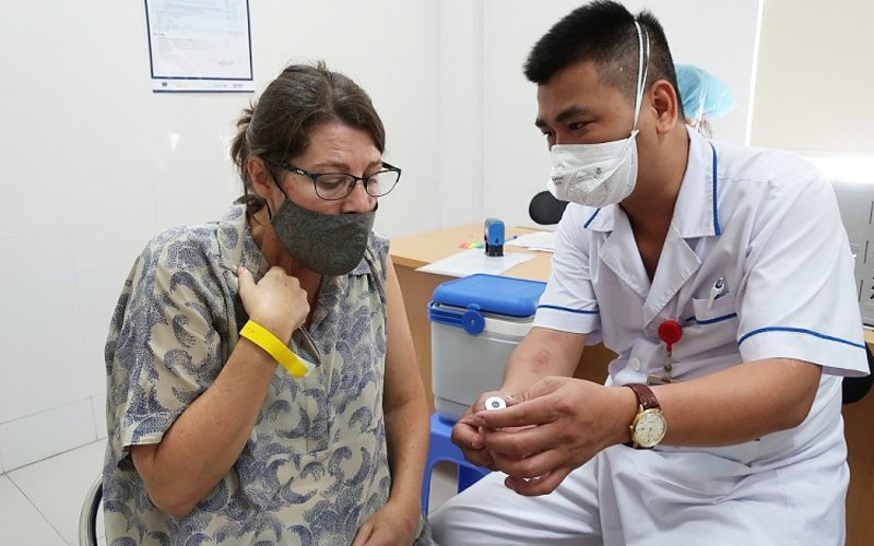 Nhân viên y tế cung cấp thông tin vaccine cho một cán bộ của tổ chức Phi chính phủ nước ngoài tại buổi tiêm ngày 13/7 (Ảnh: BV Phổi T.Ư). 