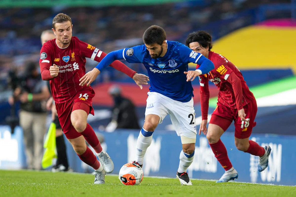 Andre Gomes trong pha tranh chấp với Jordan Henderson và Takumi Minamino. (Ảnh: AP)