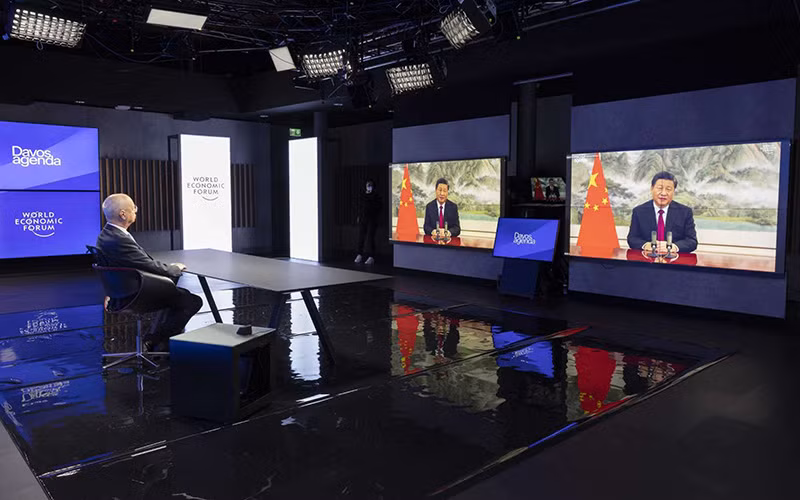 Nhà sáng lập kiêm Chủ tịch Điều hành WEF Klaus Schwab (bên trái) nghe Chủ tịch Trung Quốc Tập Cận Bình (ảnh màn hình) phát biểu tại Hội nghị trực tuyến WEF. (Ảnh: AP)