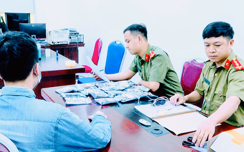 Công an làm việc với đối tượng có thiết bị công nghệ cao bị thu giữ. (Ảnh: Công an cung cấp) 