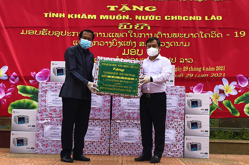 Bí thư Tỉnh ủy Quảng Bình Vũ Đại Thắng (áo trắng) trao tặng thiết bị phòng chống dịch cho lãnh đạo tỉnh Khăm Muộn.