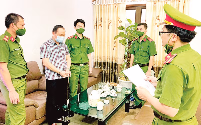 Cơ quan Cảnh sát điều tra Công an tỉnh Tuyên Quang đọc quyết định khởi tố bị can trong vụ án lợi dụng chức vụ, quyền hạn trong khi thi hành công vụ xảy ra tại Công ty Cổ phần Dịch vụ Môi trường và Quản lý đô thị Tuyên Quang, tháng 10/2021. (Ảnh BỘ CÔNG AN) 