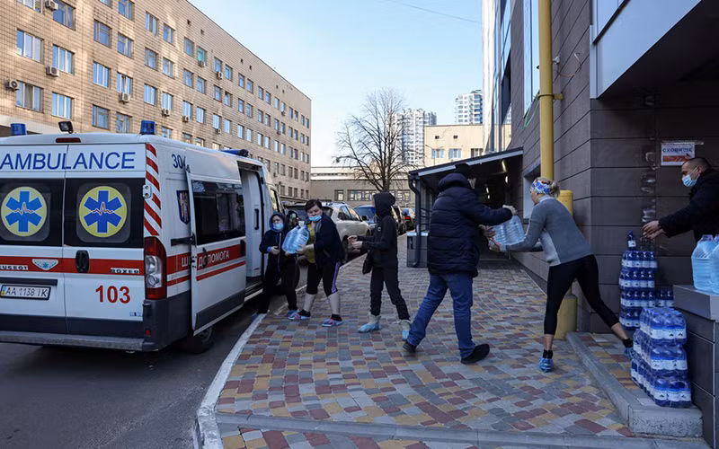 Nhân viên Bệnh viện Nhi Okhmadet tại Kiev, Ukraine, chuyển nước từ xe cứu thương, ngày 28/2. (Ảnh: Reuters)
