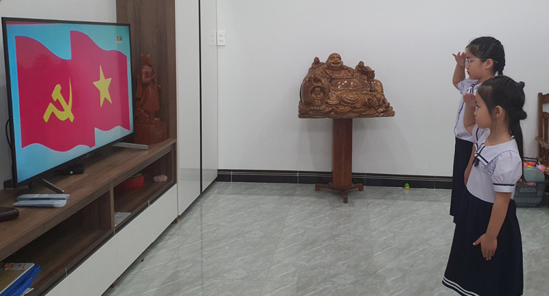 Học sinh Trường Tiểu học Lê Hồng Phong (TP Kon Tum) chào cờ, tham dự lễ khai giảng qua truyền hình. (Ảnh: Phúc Thắng) Chùm ảnh: Học sinh cả nước dự lễ khai giảng trực tuyến năm học mới 2021-2022 -2
