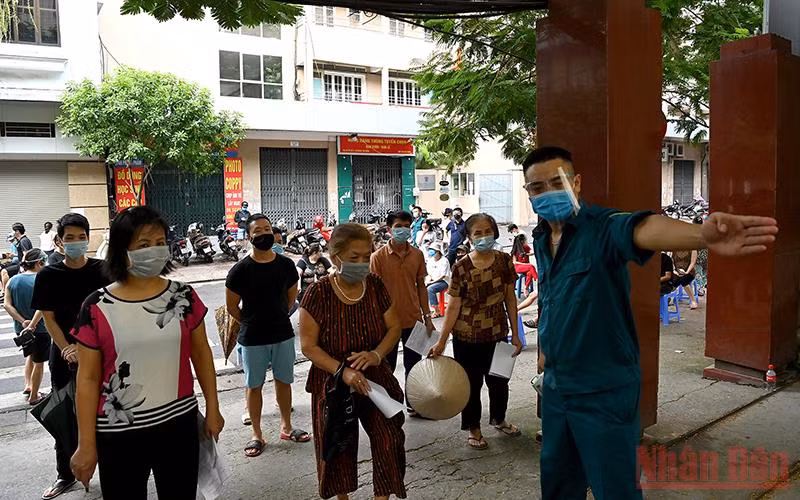 Hướng dẫn người dân khai báo tiêm chủng. (Ảnh: DUY LINH)